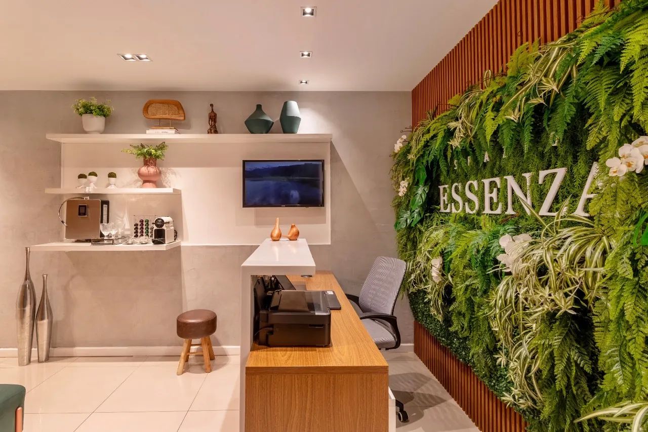 Recepção da Spazio Essenza, com o jardim vertical e o nome da clínica na parede